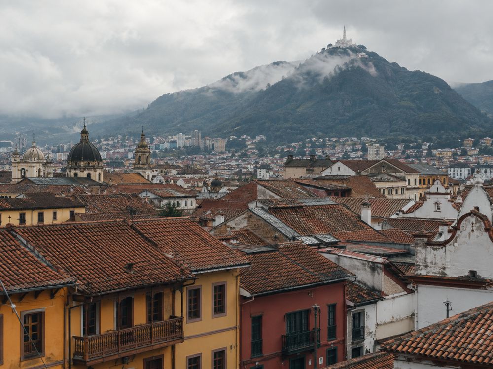 Terracotta rooftops of La Candelaria in Bogotá with Monserrate rising into low cloud behind